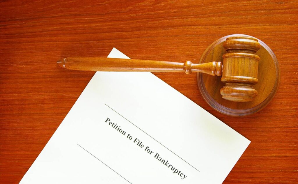 A judge's gavel and paper on a wooden desk in a courtroom | Filing For Bankruptcy | Grady BK