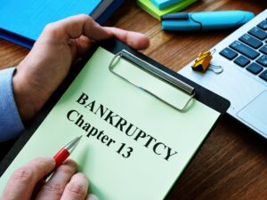 Clipboard with green paper that says BANKRUPTCY Chapter 13