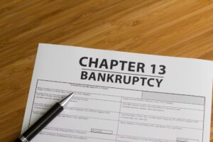 Paperwork that says Chapter 13 Bankruptcy with a pen